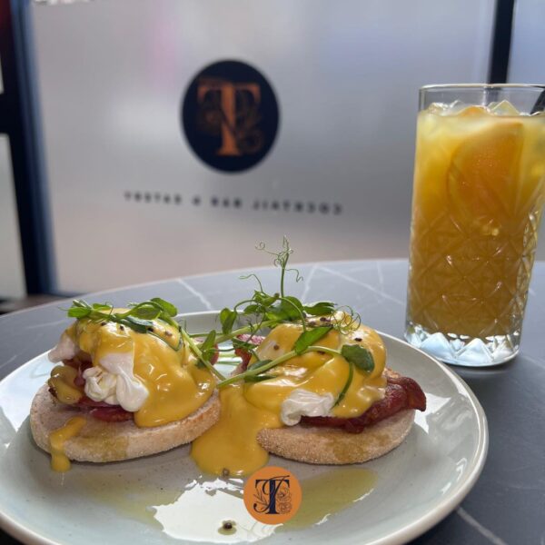 eggs benedict and a tall glass of something juicy for Bottomless Brunch at TigerIvy