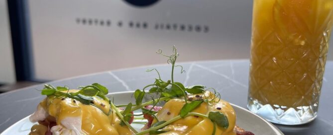 eggs benedict and a tall glass of something juicy for Bottomless Brunch at TigerIvy