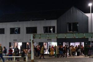 Exterior of the Auxiliary warehouse with crowds of people outside