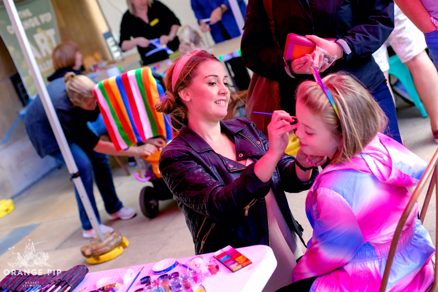 A child getting their face painted at Orange Pip market