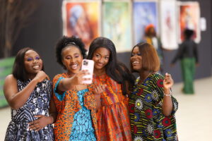 four women in colourful dresses taking a selfie
