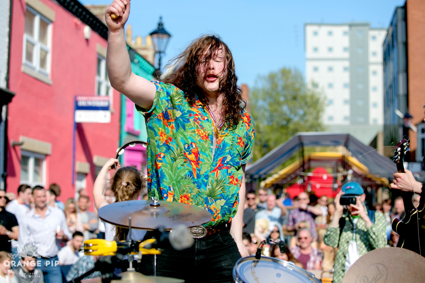 Someone playing drums live on a sunny Orange Pip market day