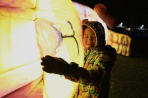 Middlesbrough Storytelling Festival Child holds a giant illuminated inflatable animal